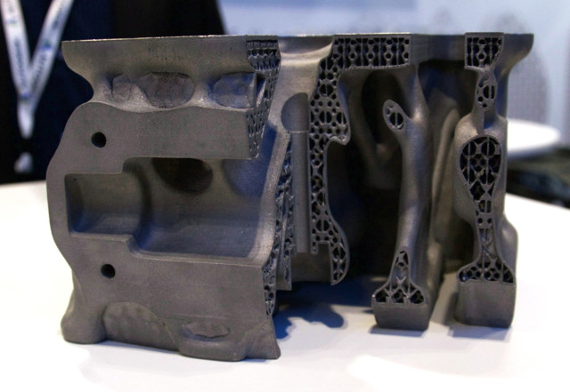 The part optimized for 3D printing features a complex interior geometry that reduces weight and improves performance.