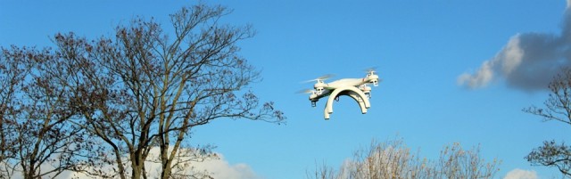 Unmanned aircraft flying above trees.
