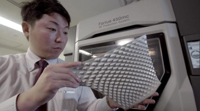 A Daihatsu employee examines a 3D-printed Effect Skin made with a Fortus 450mc 3D printer. (Image courtesy of Stratasys.)