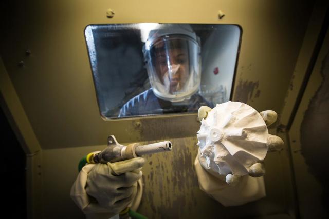 An SLS 3D-printed part being excavated in post-processing. (Image courtesy of Proto Labs.)