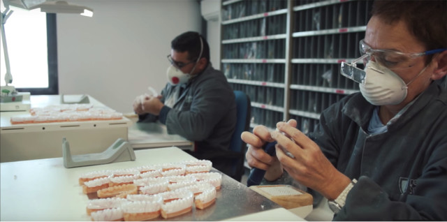 Biotech Dental technicians thermoforming aligners over 3D-printed models of patient teeth. (Image courtesy of Biotech Dental.)