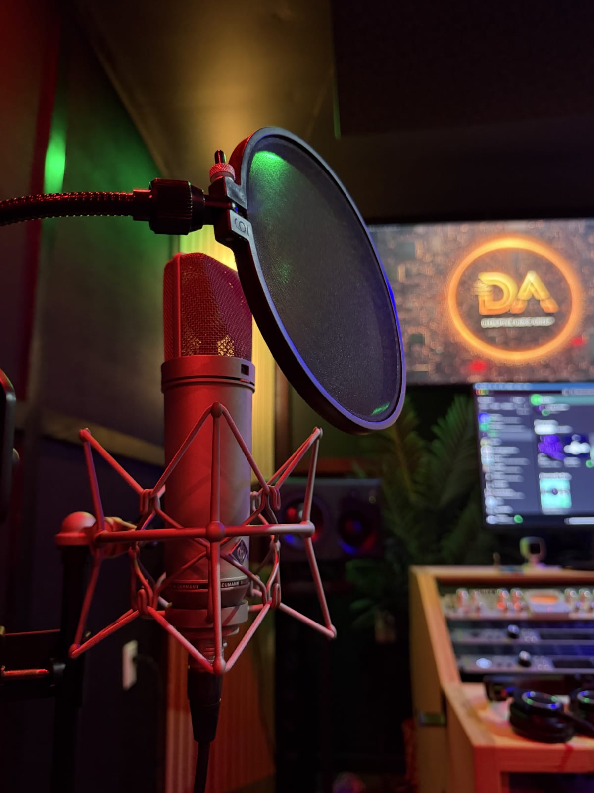 Studio microphone in front of the glowing Disruptive Audio Group logo