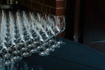 Empty wine glasses on a navy blue table laid out ready for a wine tasting.
