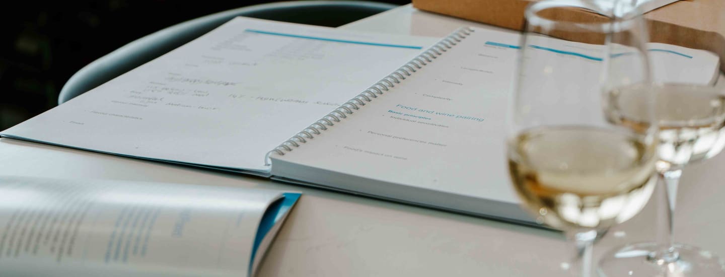 An image of a textbook with a pair of wine glasses in the foreground