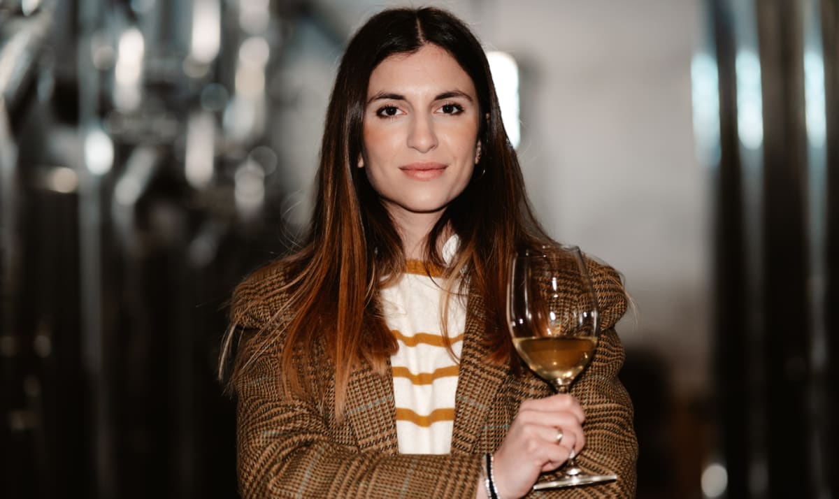 Ilaria Felluga with a glass of white wine in the winery cellars