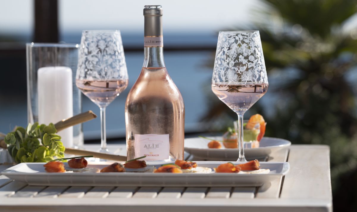 Bottle of Alie Rose on a tray with glasses and snacks