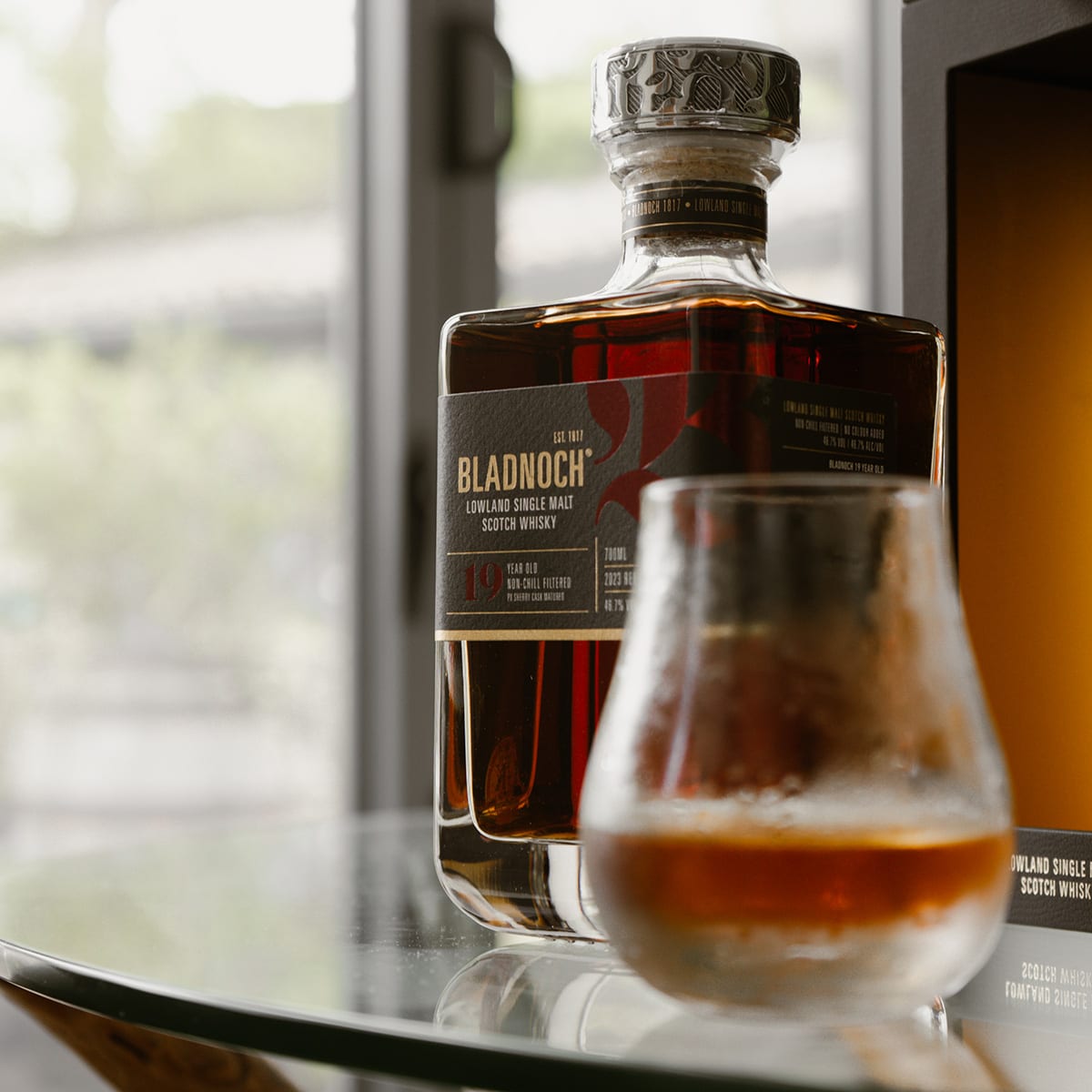A glass of Bladnoch 19yo in the foreground, with a bottle in the background