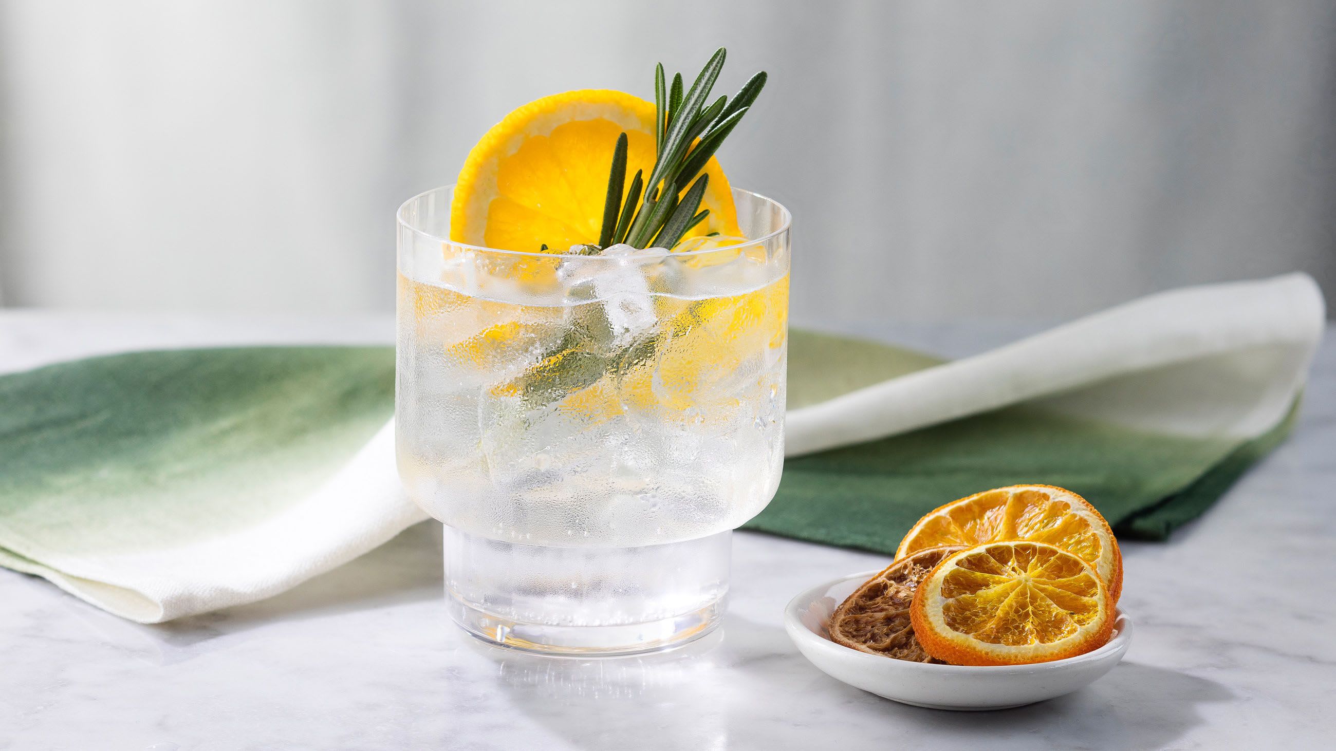 Gin and tonic garnished with orange and rosemary Gin and tonic garnished with orange and rosemary
