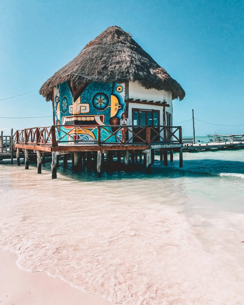 Colorful beach hut on stilts in turquoise water, Mexico