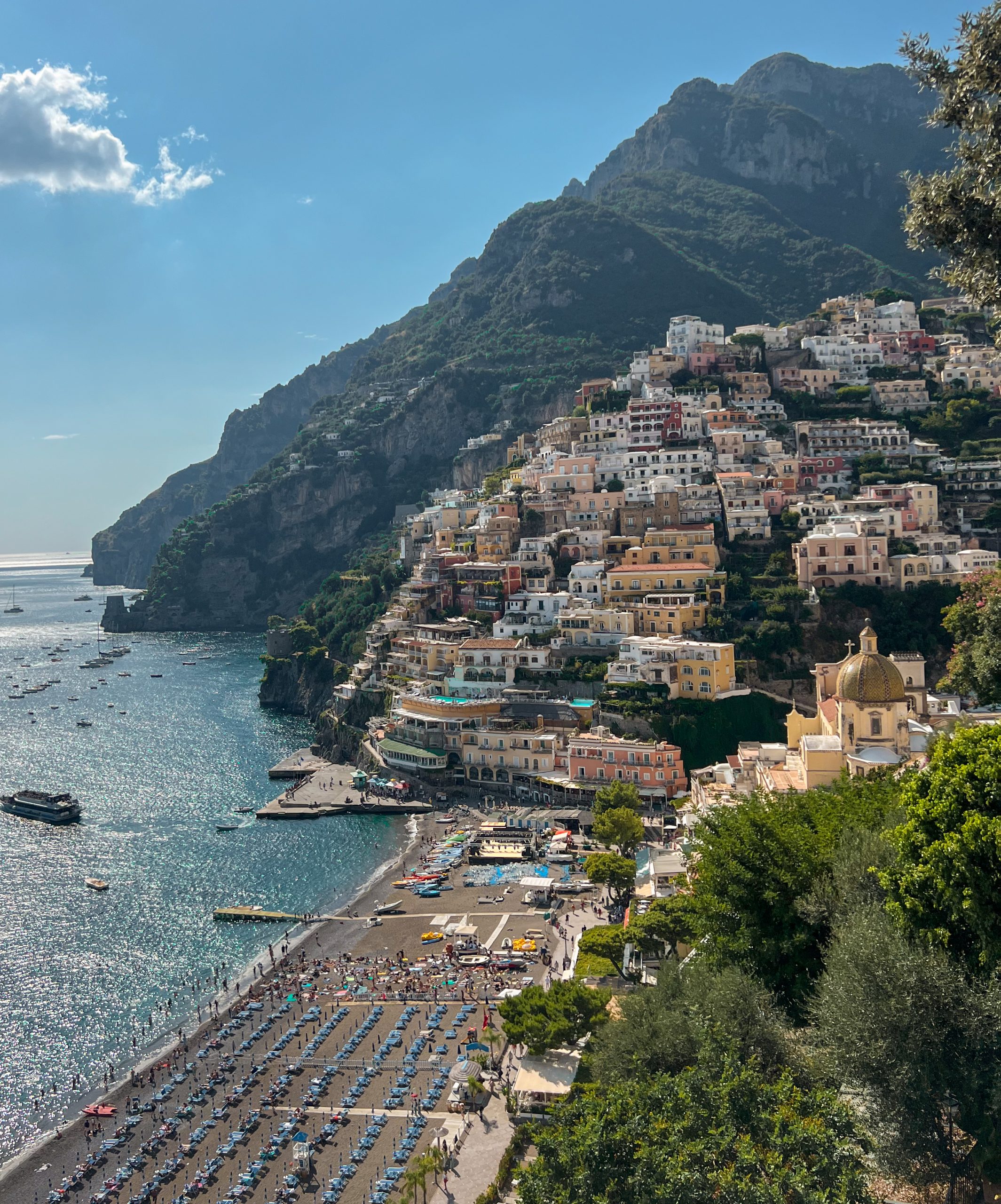 Positano an der Amalfiküste: bunte Häuser an steilen Klippen, belebter Strand und türkisblaues Mittelmeer