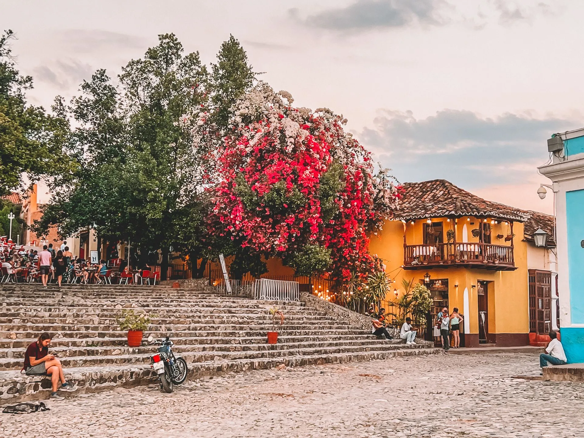 Koloniale Plaza in Trinidad, Kuba, mit blühenden Bougainvilleen, Kopfsteinpflaster und bunten Fassaden bei Sonnenuntergang.