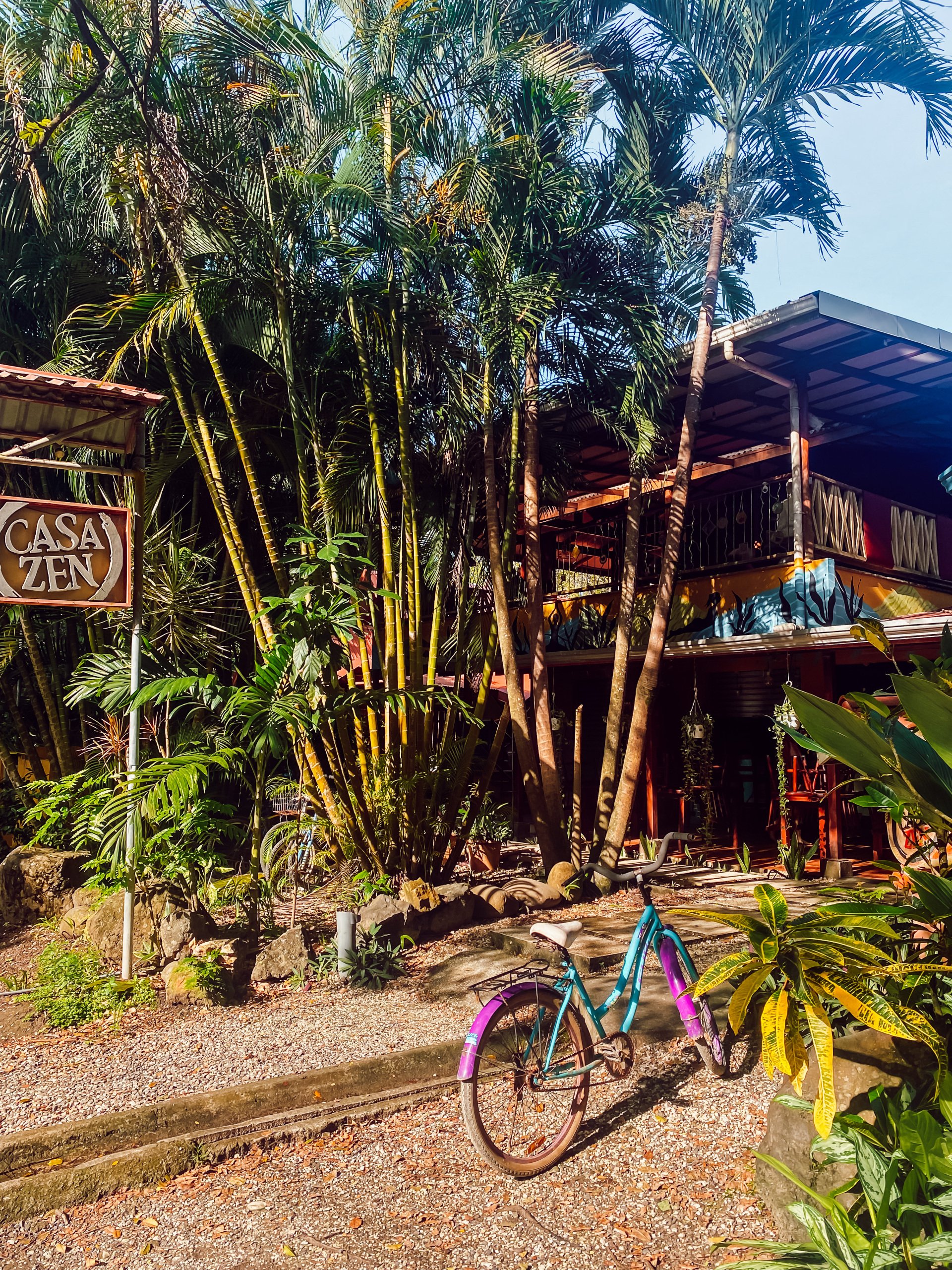 Farbenfrohes Fahrrad vor Casa Zen Hostel, umgeben von tropischer Vegetation in Costa Rica
