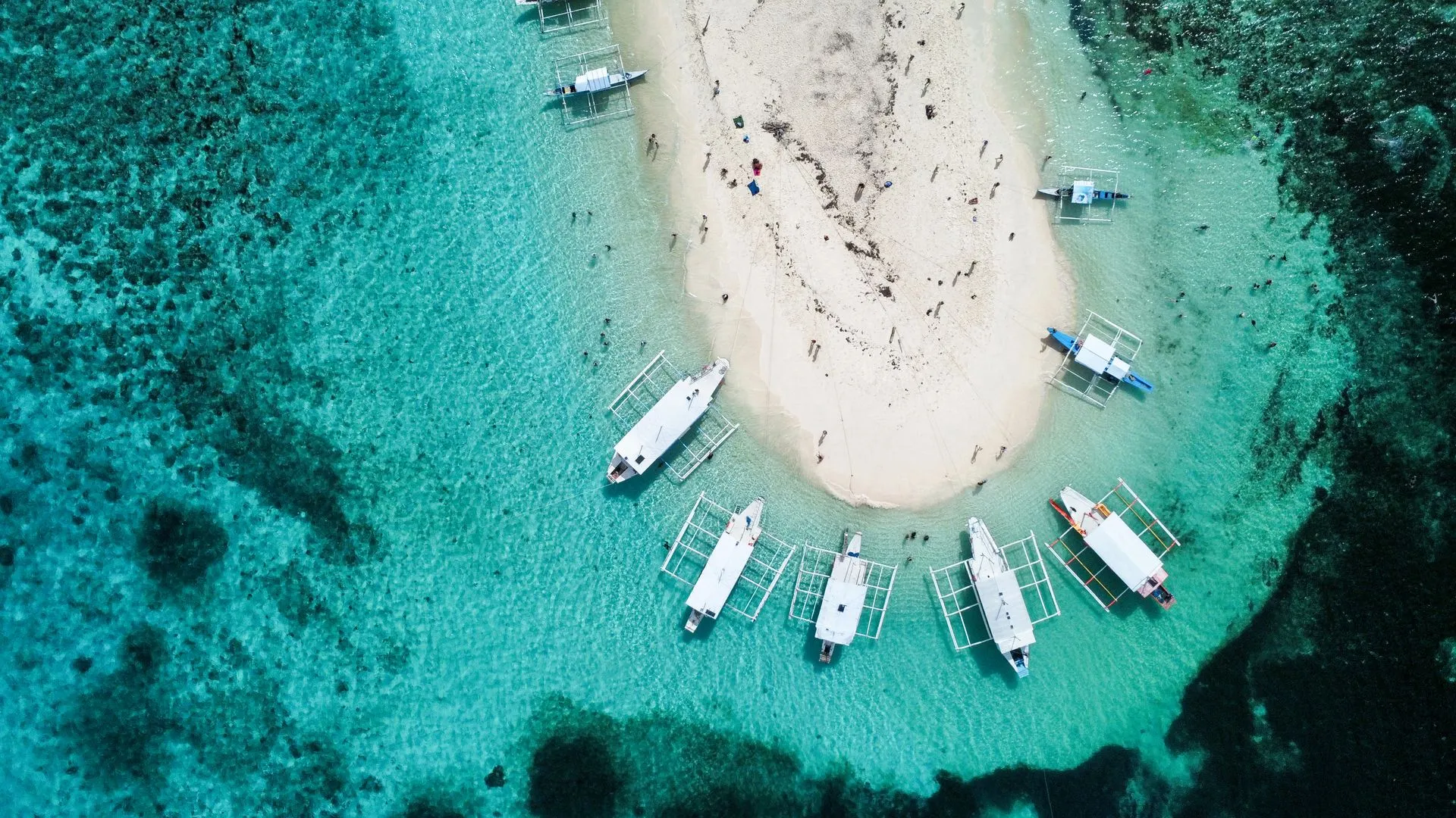 Luftaufnahme einer Sandbank auf den Philippinen mit türkisblauem Wasser und Auslegerboten