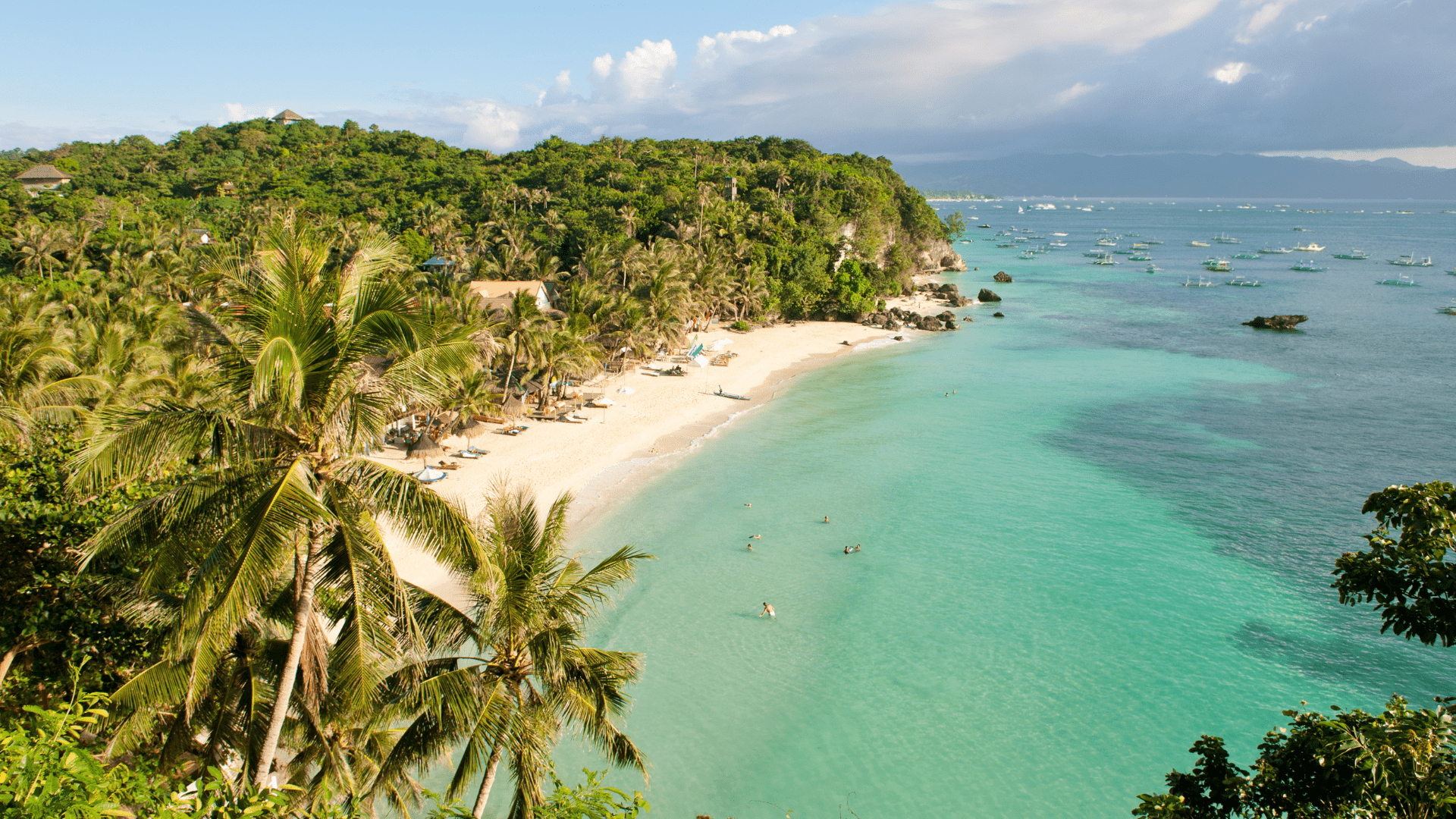 Traumstrand auf den Philippinen mit türkisblauem Wasser, weißem Sand und üppigen Palmen von oben