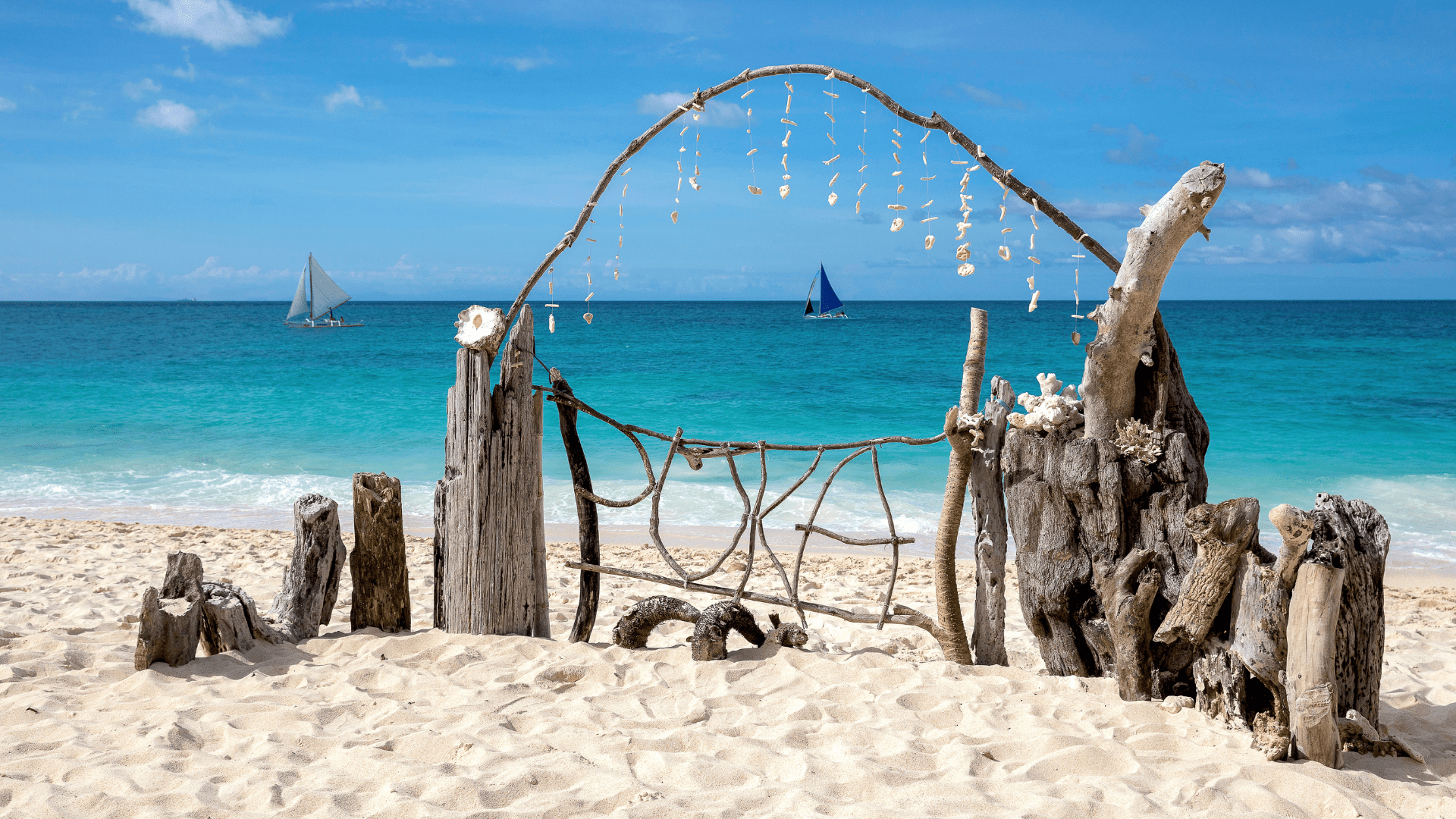 Treibholz-Stranddeko mit Muscheln am weißen Strand von Boracay, Philippinen, mit türkisblauem Meer