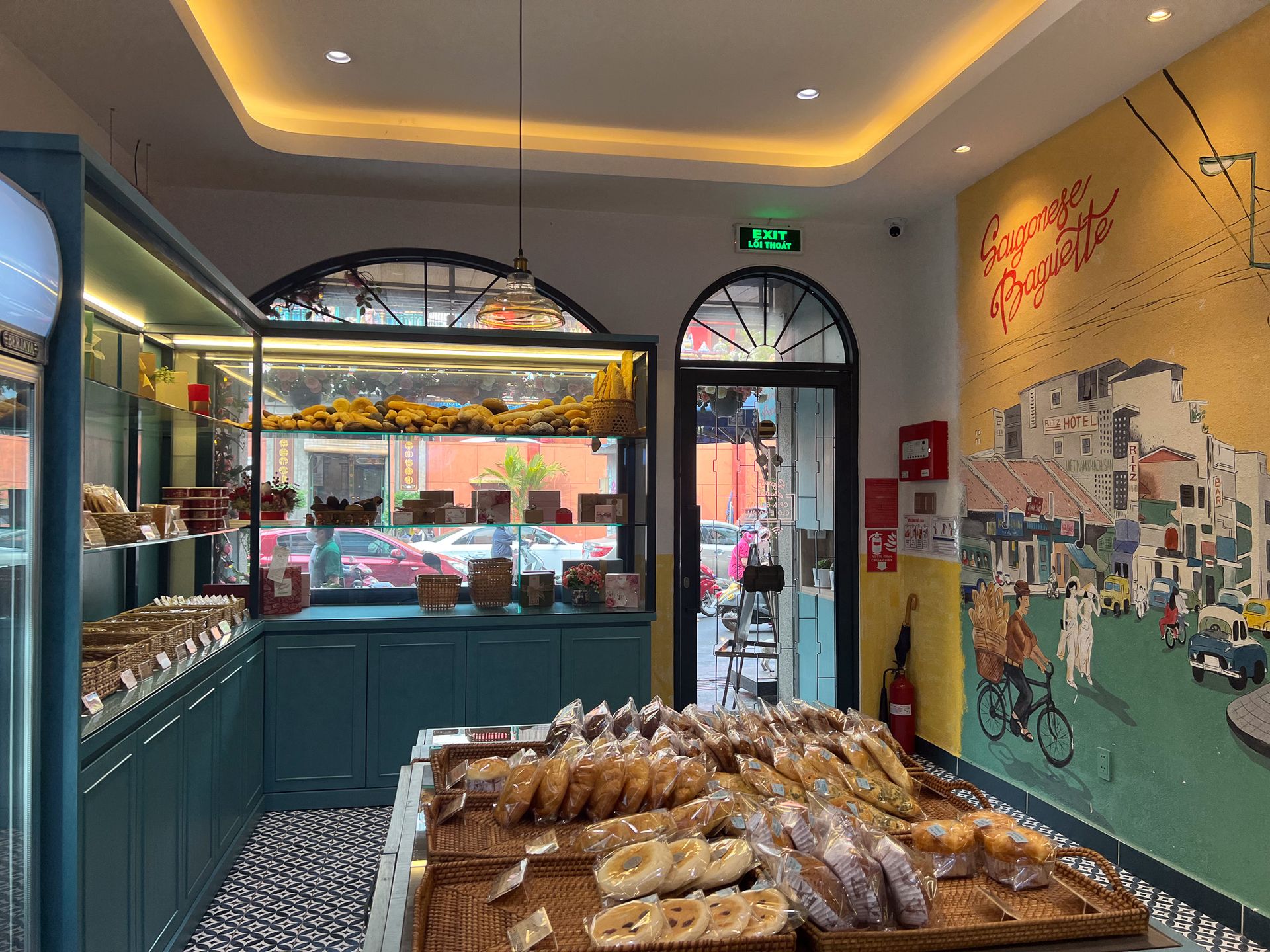 Saigonese Baguette Bäckerei in Ho-Chi-Minh-Stadt mit frischen Bánh mì und nostalgischem Wandgemälde, Vietnam