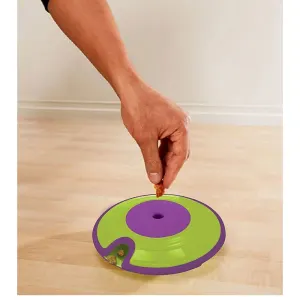 person placing treat into the dog treat maze puzzle toy