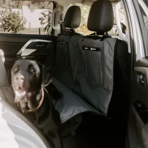 dog laying on cover in car