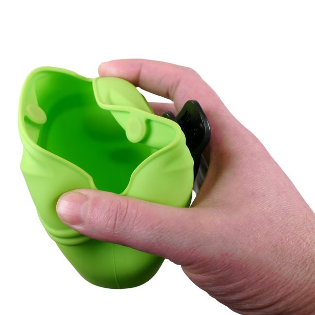 green silicone Dog Treat Bag showing as opened with human hand