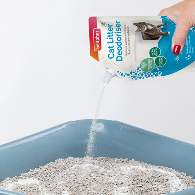 Deodoriser granules being poured into a litter box