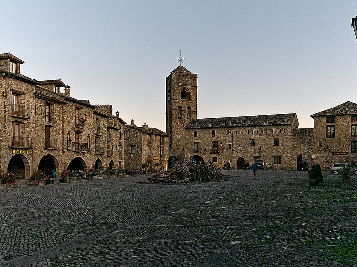 Plaza Mayor porticada de piedra de Aínsa, con su torre y soportales