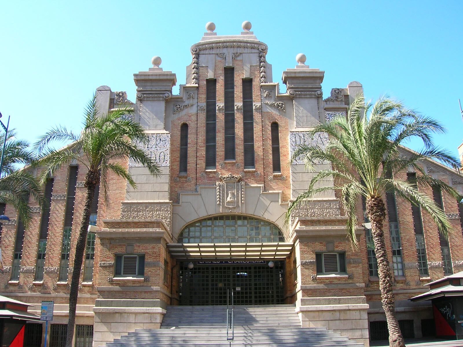 Fachada modernista del Mercado Central de Alicante flanqueada por palmeras