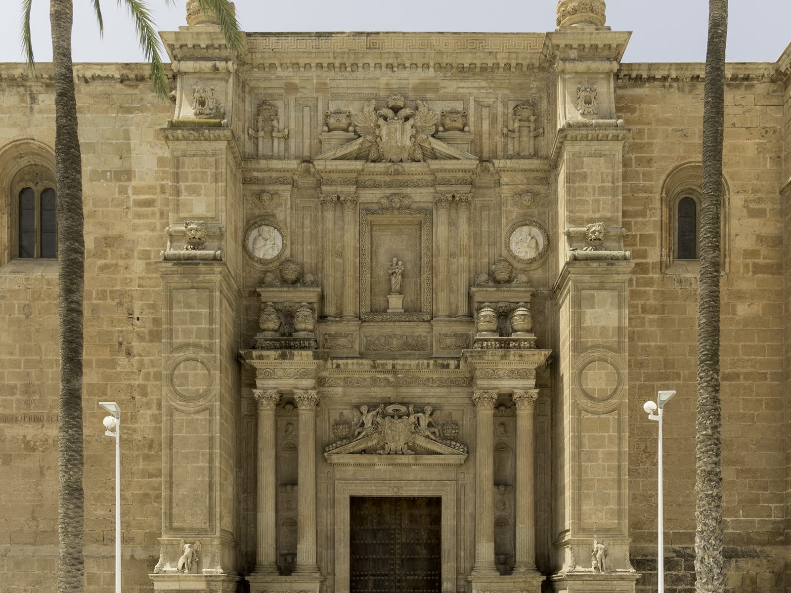 Fachada principal de la Catedral de Almería flanqueada por palmeras