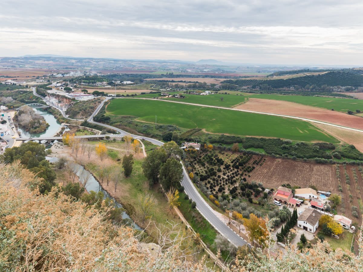 El río Guadalete serpenteando entre campos de cultivo a los pies del peñón de Arcos de la Frontera