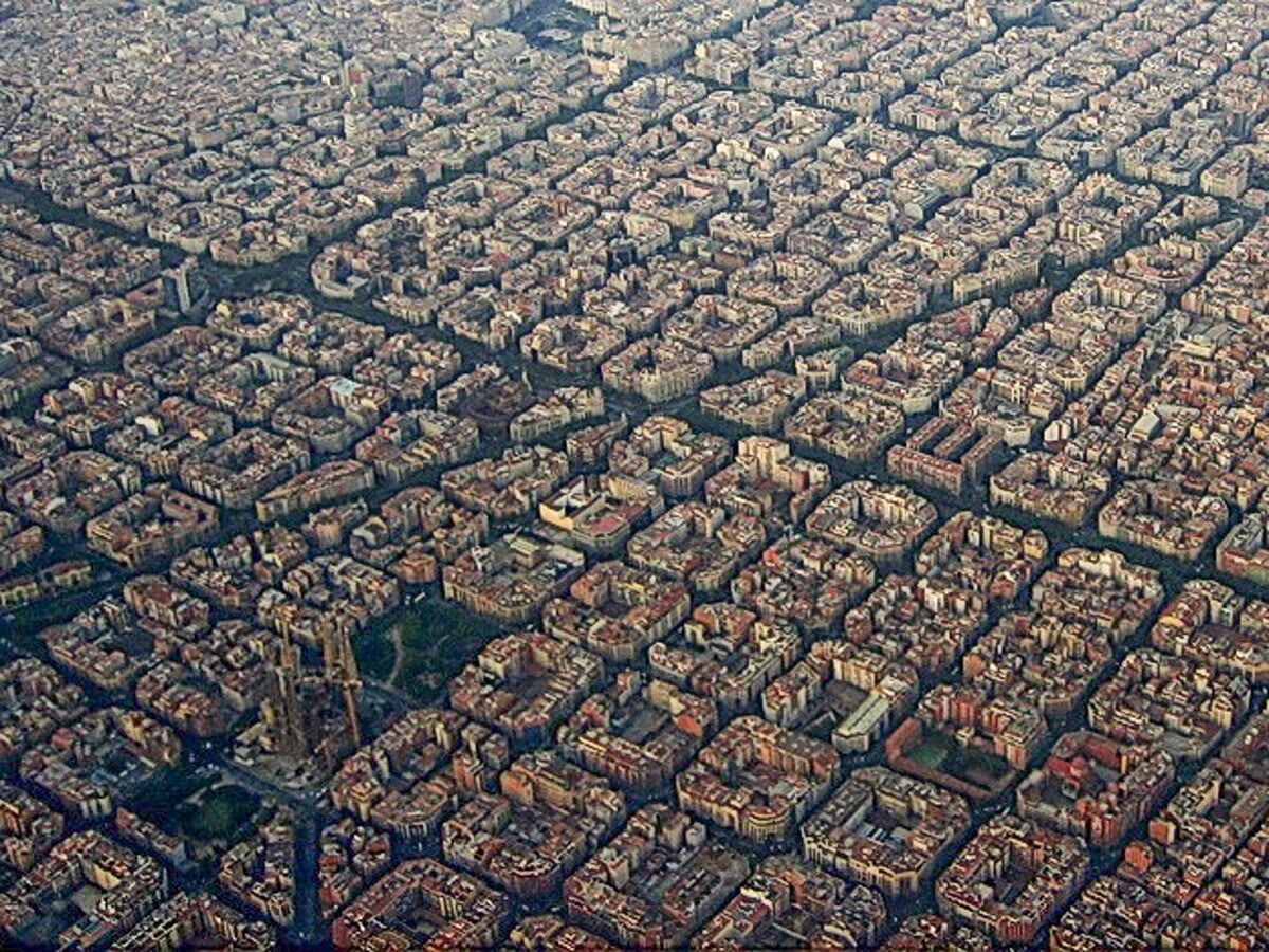 Vista aérea de la cuadrícula del Eixample de Barcelona con la Sagrada Família asomando entre los bloques