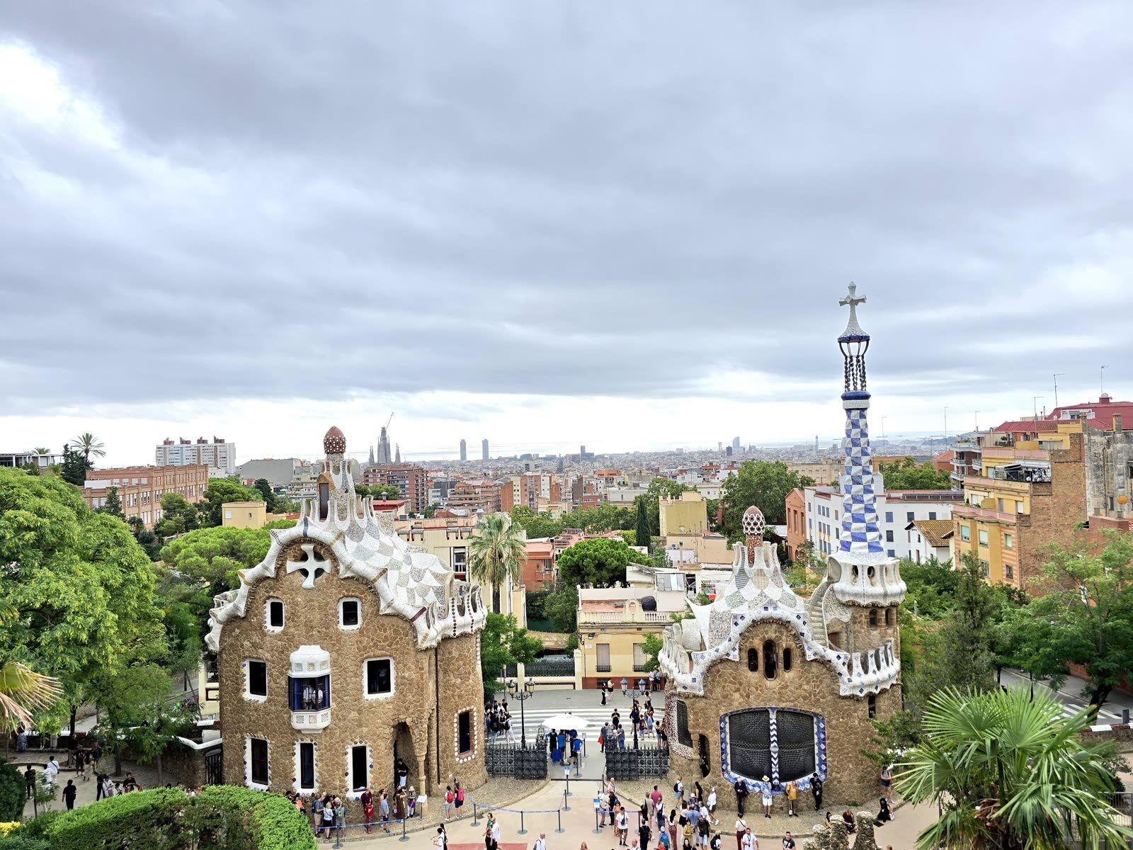 Vista elevada de los pabellones de Park Güell en Barcelona, con la ciudad y el mar al fondo
