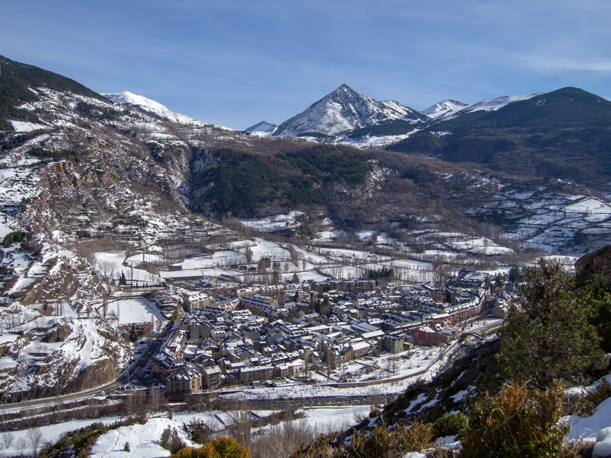 El pueblo de Benasque nevado en el fondo del valle, rodeado de montañas pirenaicas