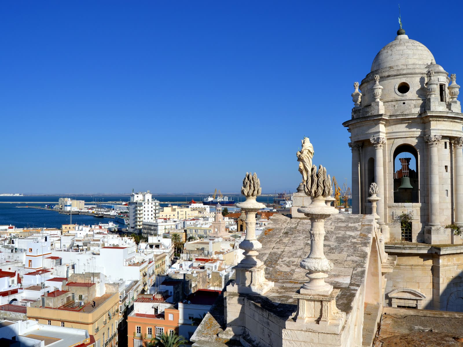 Vista desde la torre de la Catedral de Cádiz hacia el puerto y la Bahía de Cádiz, con grúas y barcos atracados