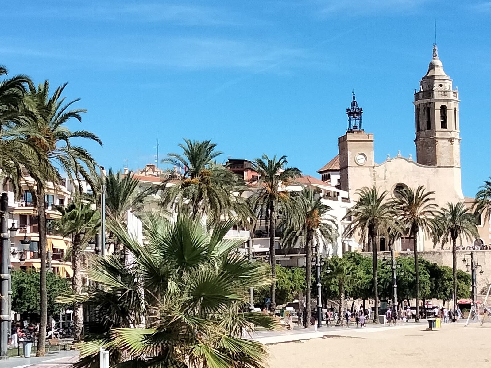 Iglesia de Sant Bartomeu i Santa Tecla en Sitges, entre palmeras junto a la playa