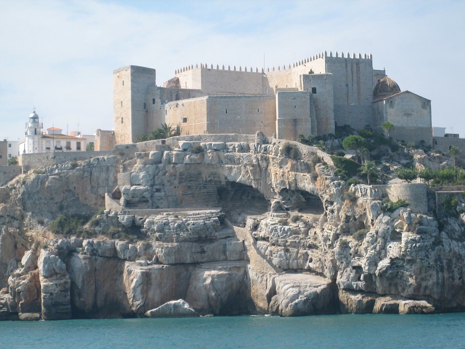 Castillo de Peñíscola sobre el peñón rocoso visto desde el mar, con el faro y el casco antiguo