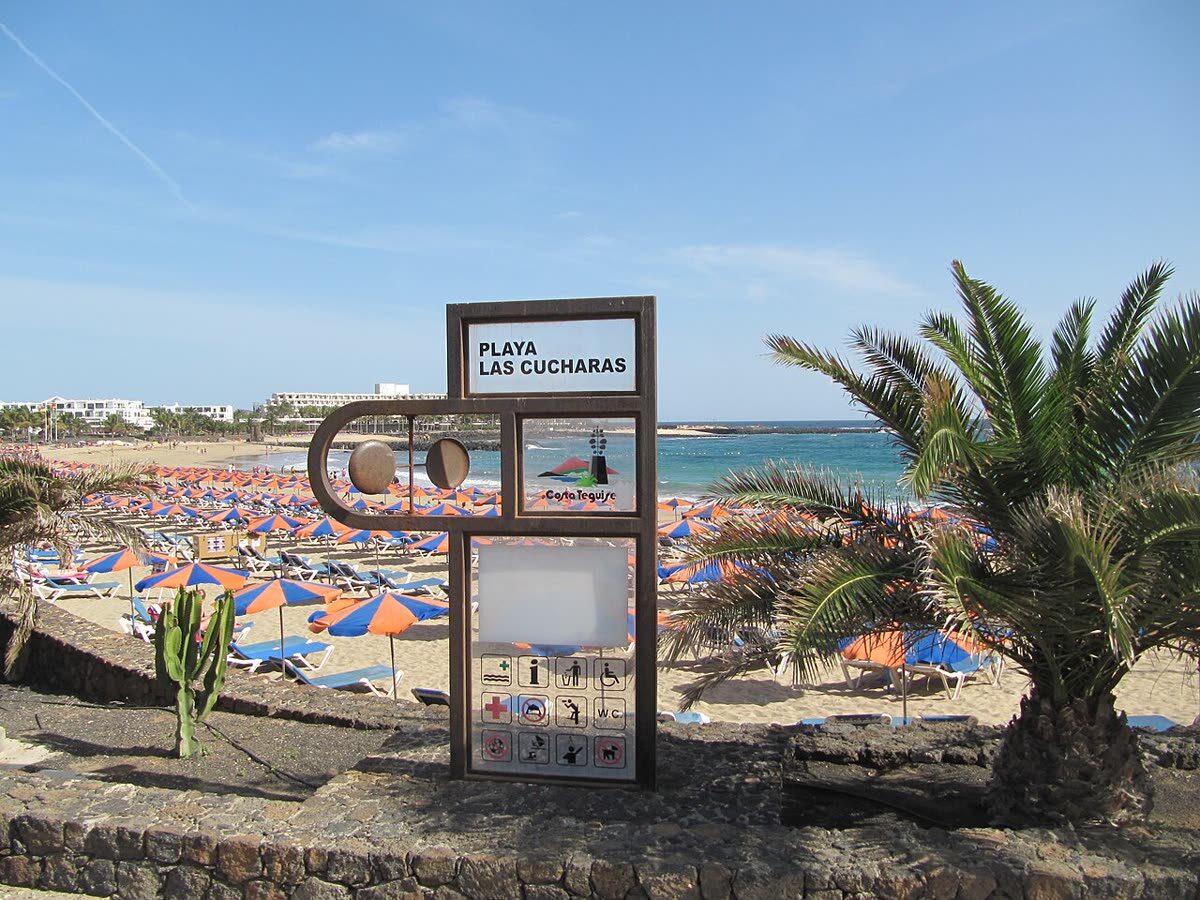 Playa de Las Cucharas en Costa Teguise, con tumbonas y el desarrollo hotelero al fondo
