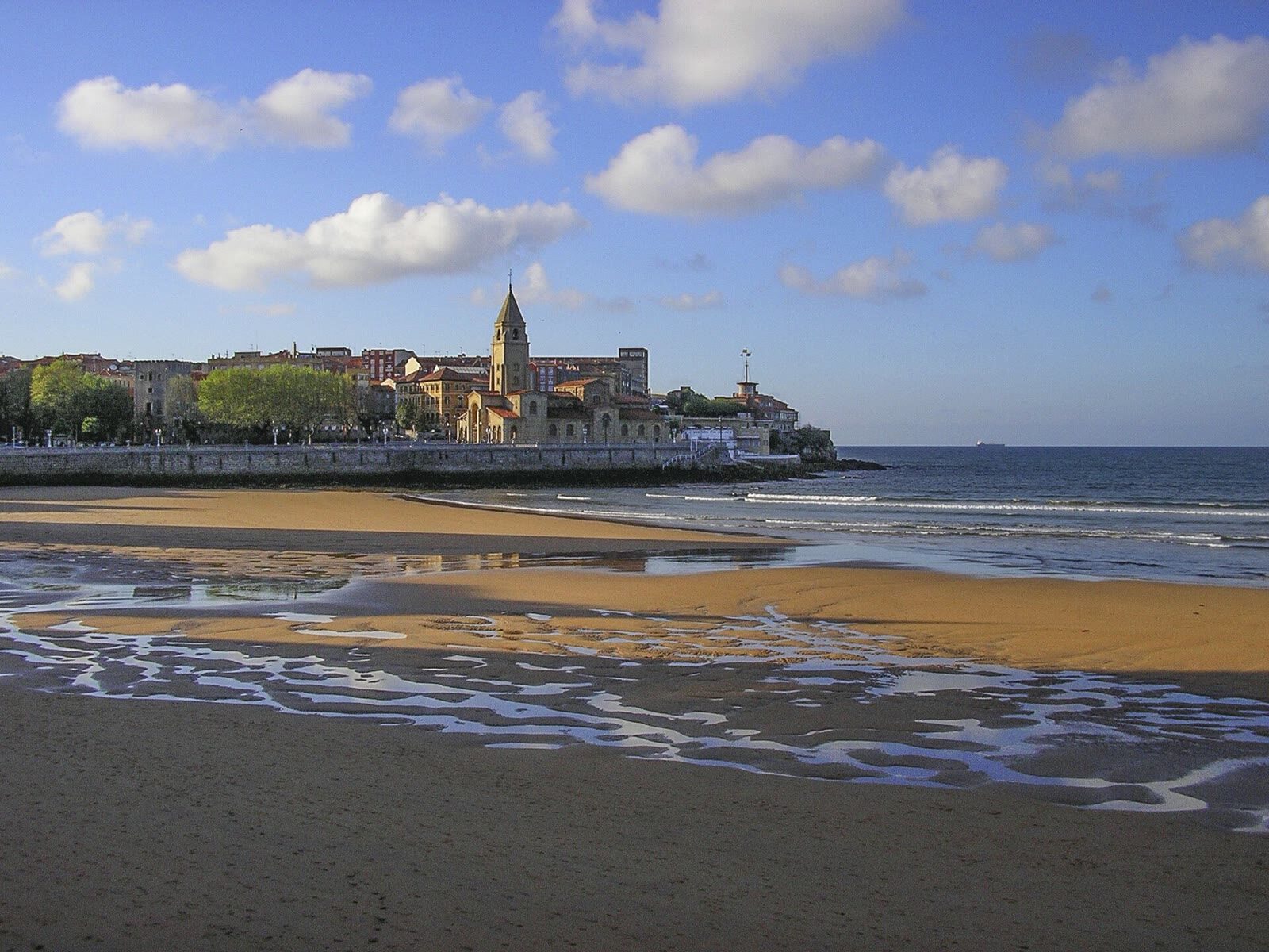 Playa de San Lorenzo en Gijón con la iglesia de San Pedro y Cimadevilla al fondo