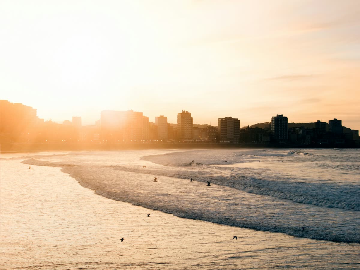 Skyline de Gijón a contraluz al atardecer desde la playa