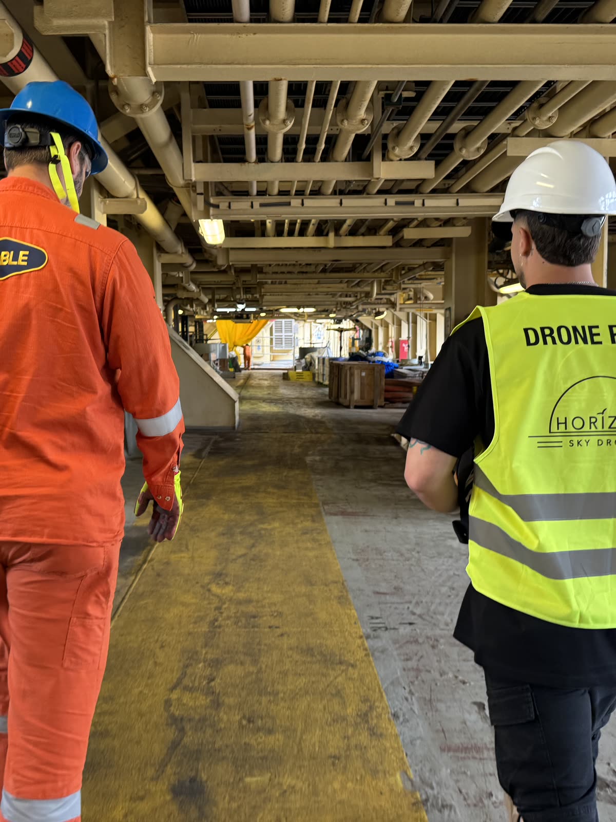 Equipo de Horizon Sky Drone con cascos de protección en un pasillo industrial