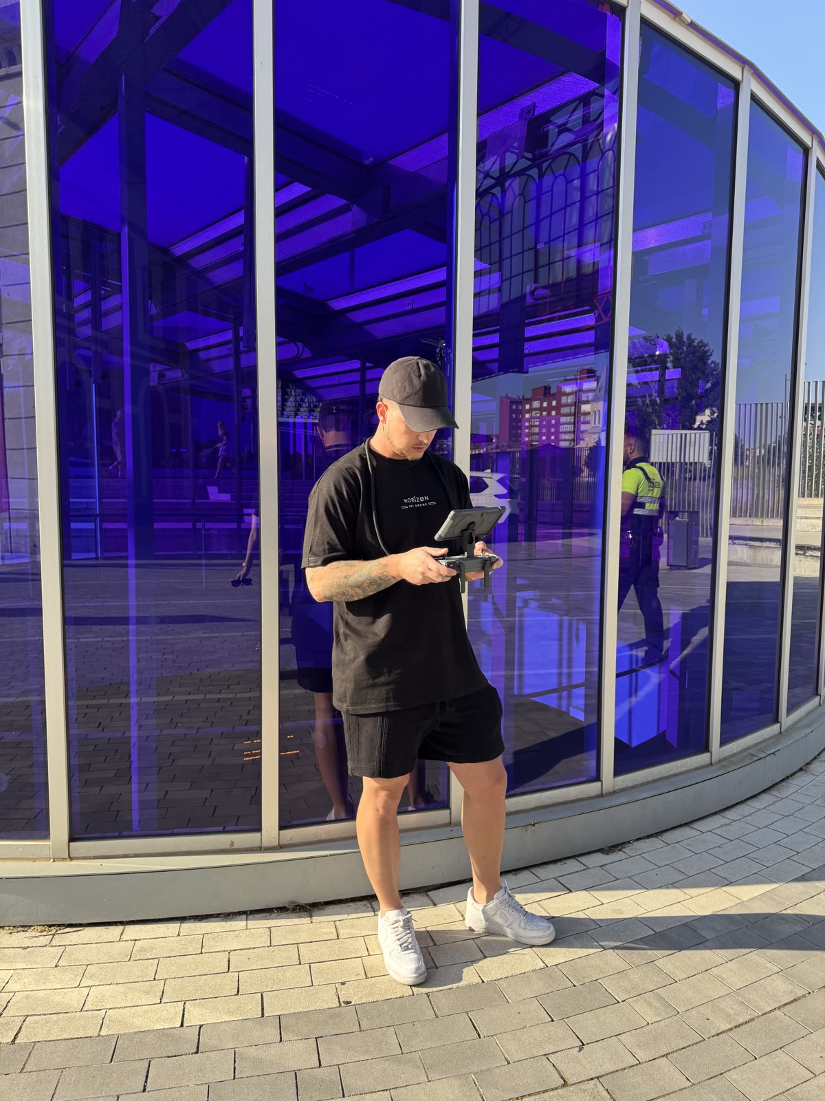 Piloto de Horizon Sky Drone con el controlador frente a un edificio de cristal