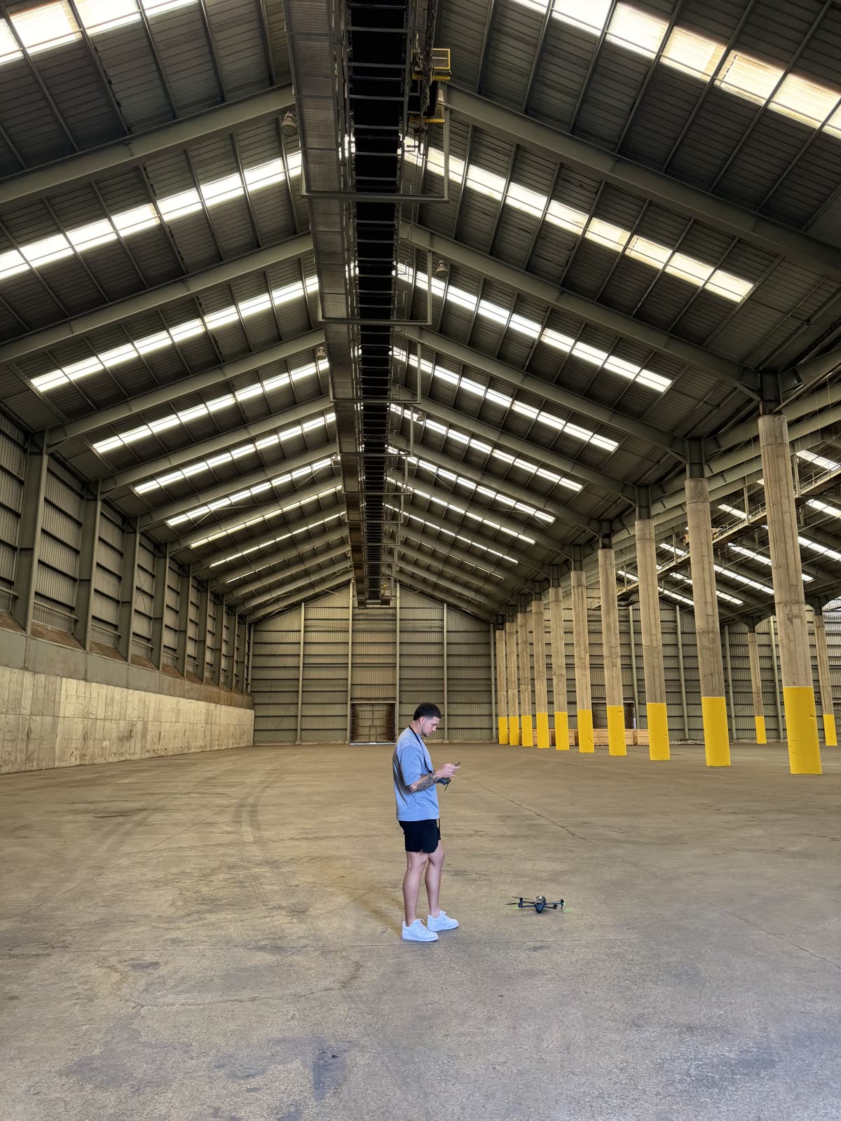 Piloto de Horizon Sky Drone haciendo despegar un dron dentro de una nave industrial vacía
