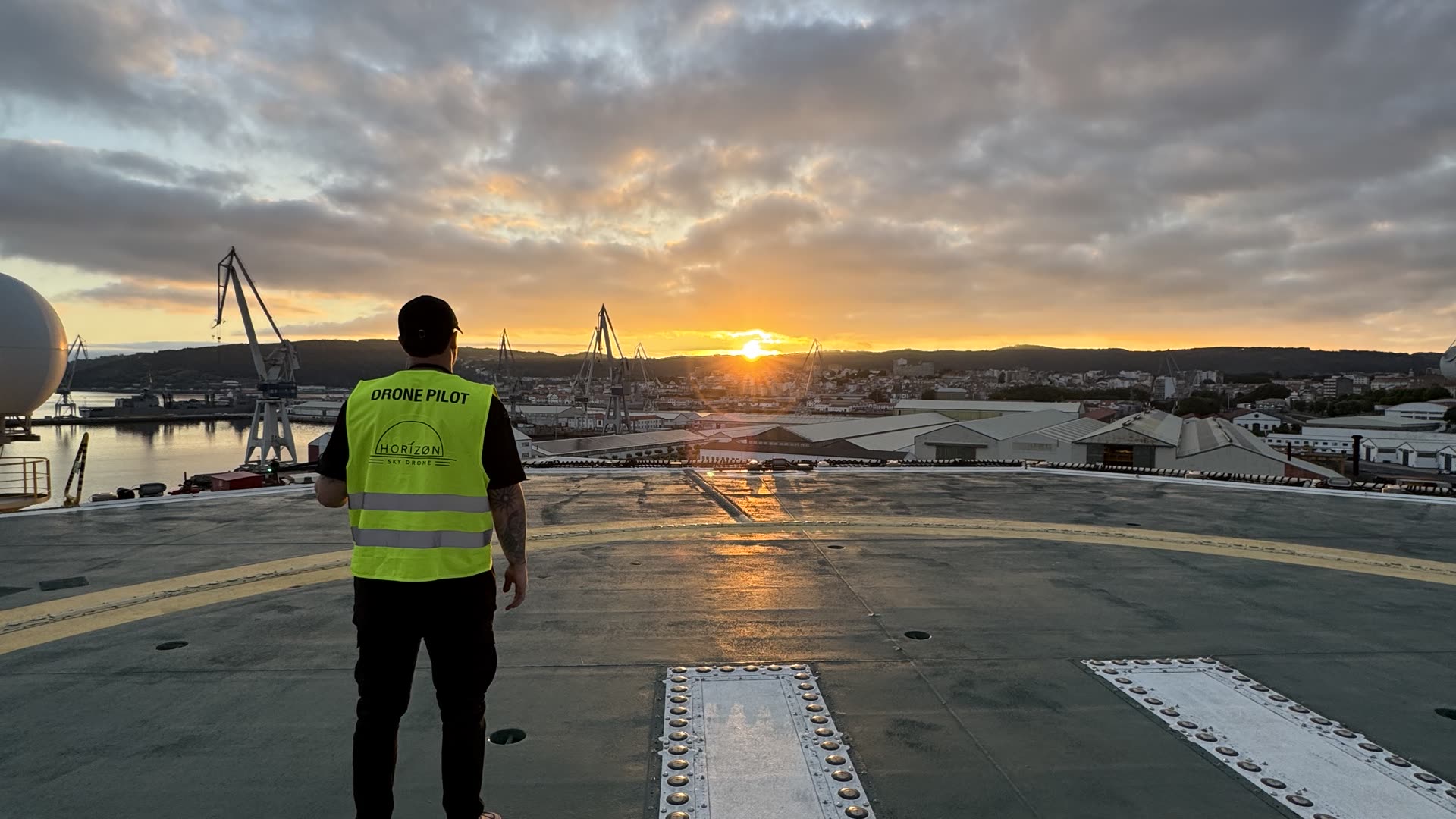 Piloto de Horizon Sky Drone en la cubierta de un buque al atardecer, junto a un puerto