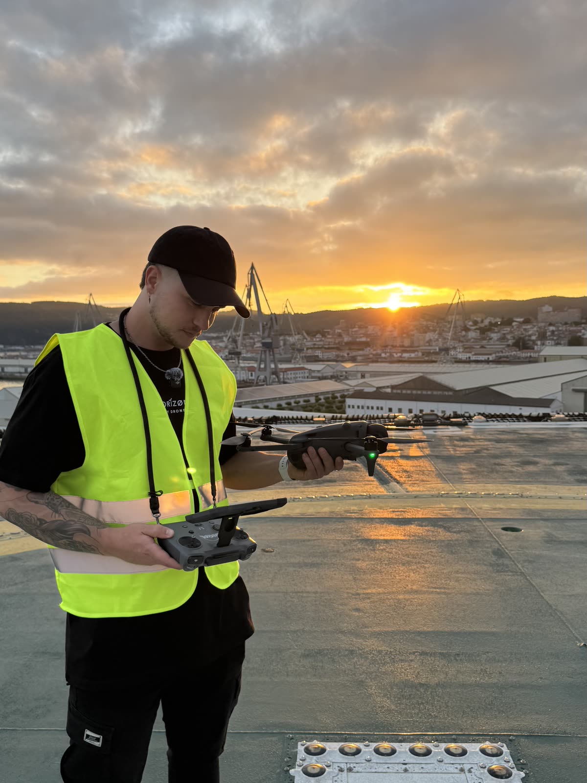 Piloto de Horizon Sky Drone haciendo despegar un dron en una azotea industrial al atardecer