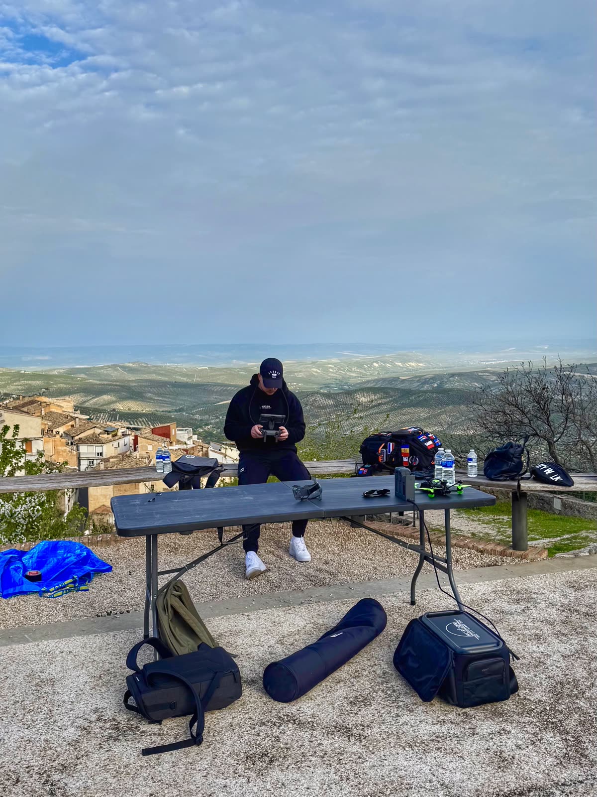 Piloto de Horizon Sky Drone preparando el equipo FPV sobre una mesa plegable con vistas a un pueblo