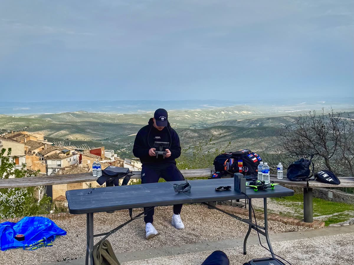 Piloto de Horizon Sky Drone preparando el equipo FPV sobre una mesa plegable con vistas a un pueblo