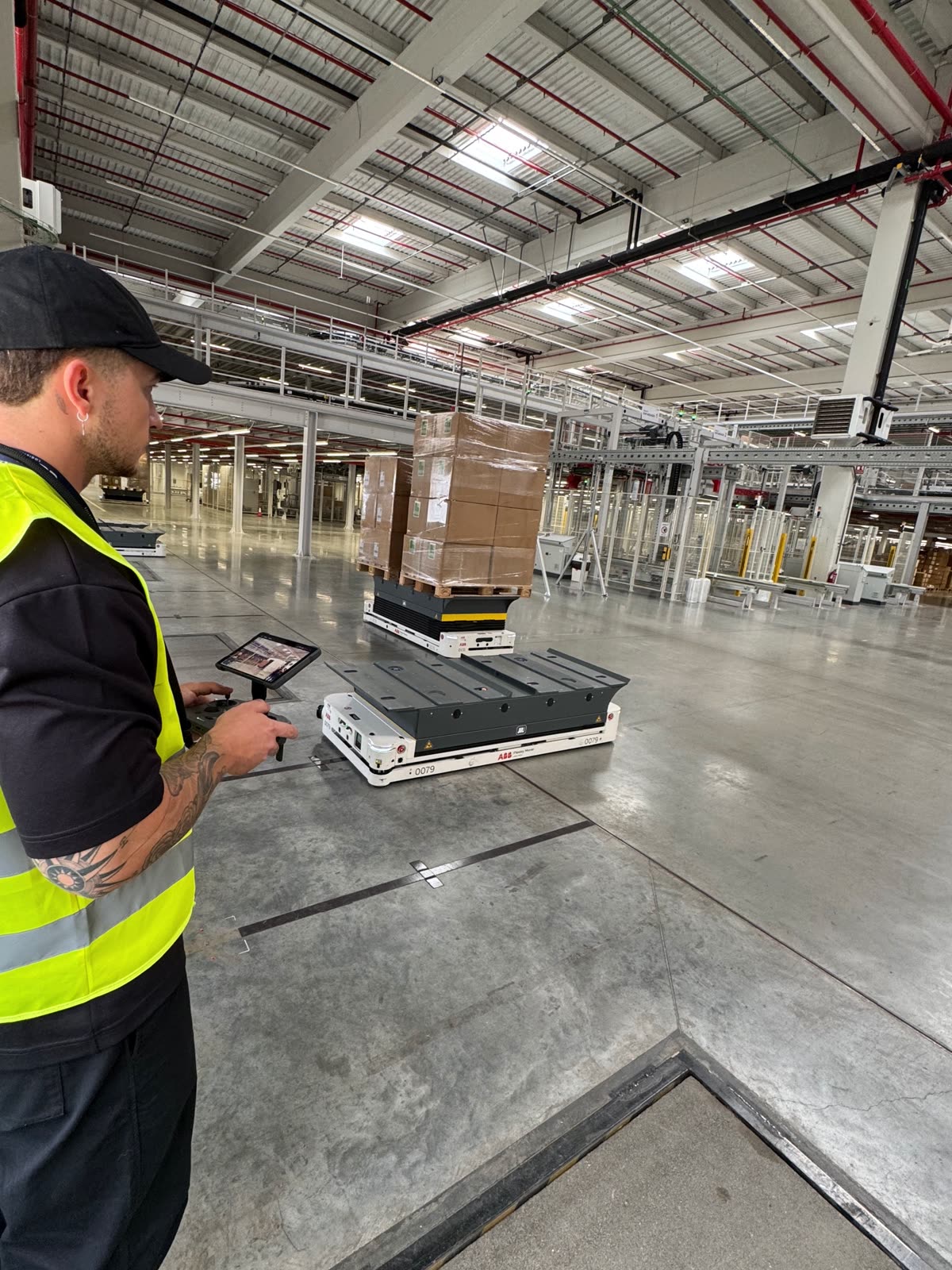 Piloto de Horizon Sky Drone junto a un robot AGV en un almacén logístico