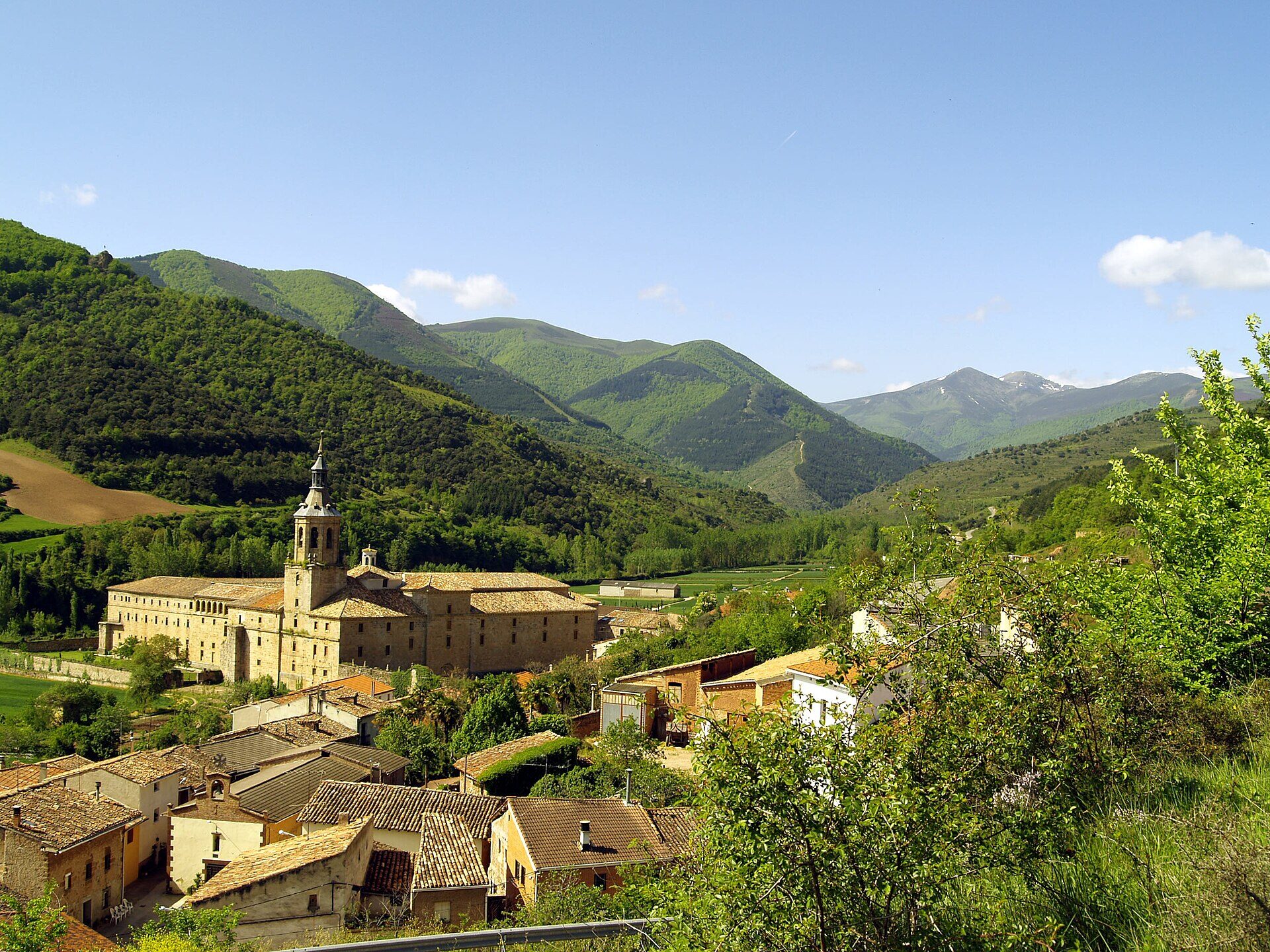 Monasterio de San Millán de Yuso en su valle, con la sierra de La Demanda al fondo