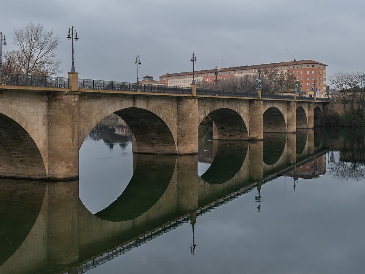 Puente de Piedra sobre el río Ebro reflejado en el agua a su paso por Logroño