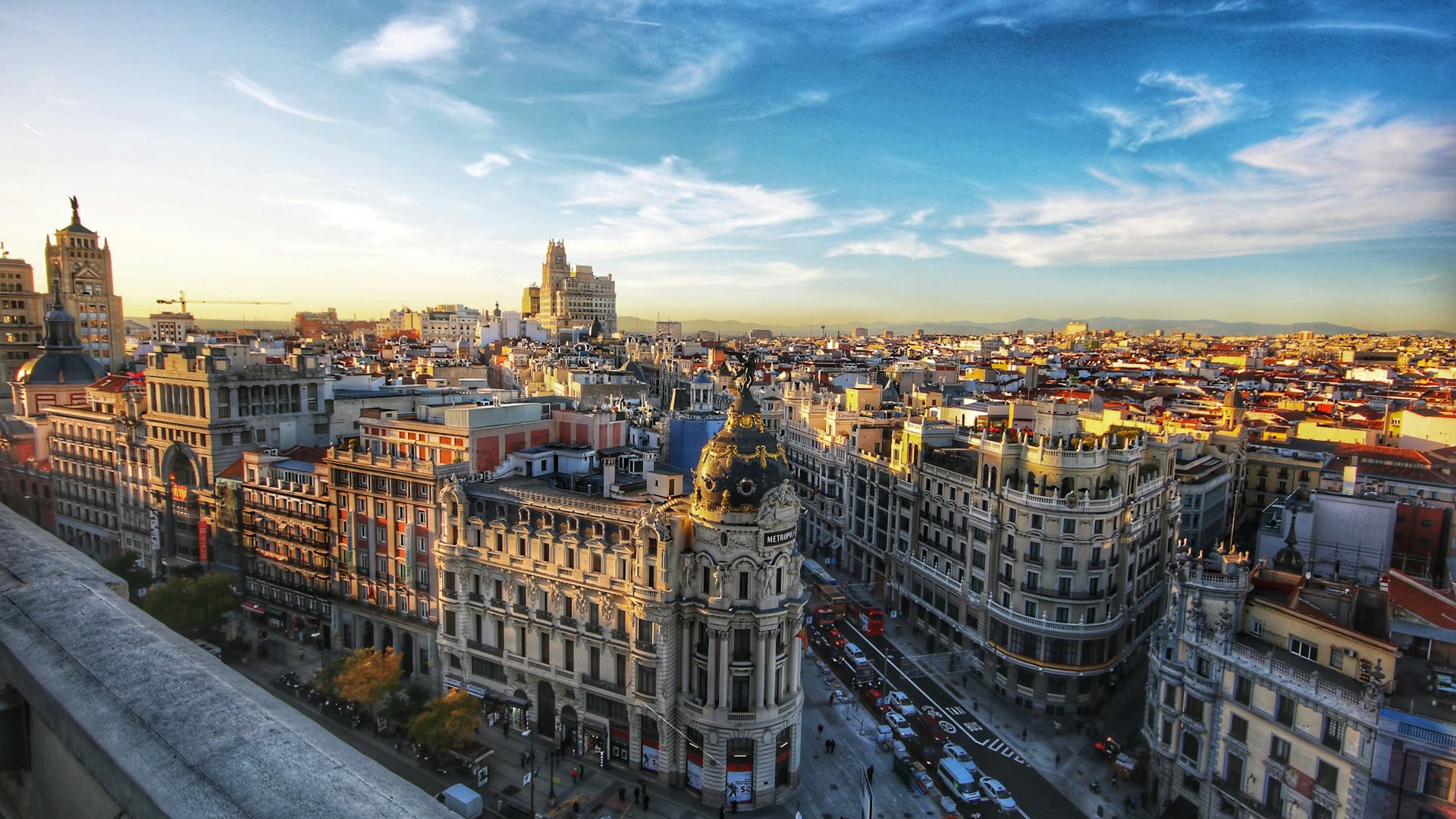 Vista aérea de Madrid al atardecer con el edificio Metrópolis en primer término