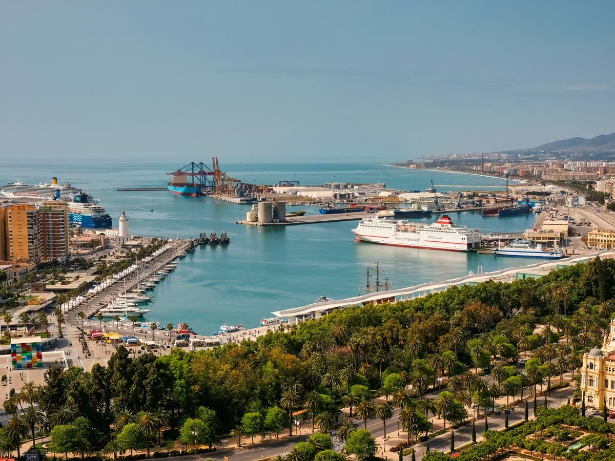 Vista aérea de un barco navegando frente a la costa y el puerto de Málaga