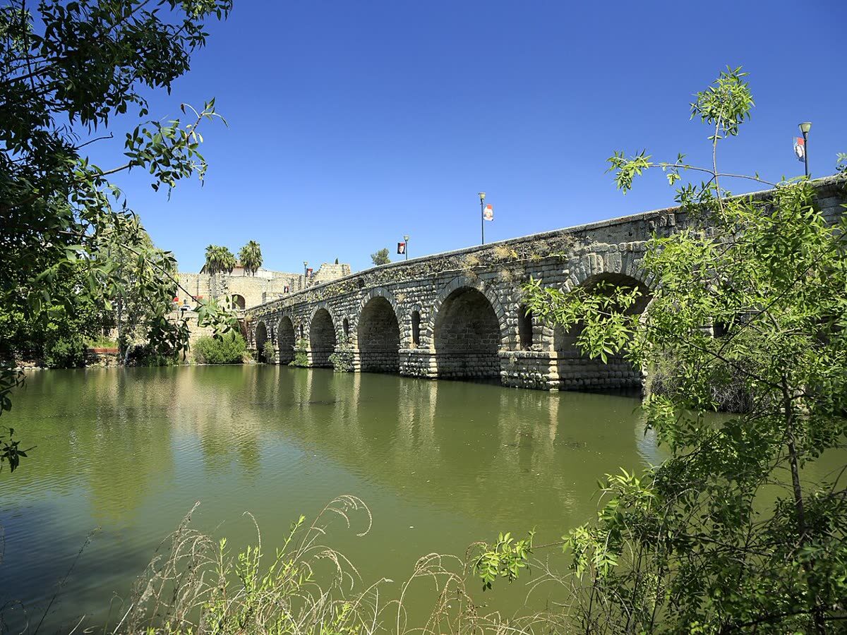 Arcos de piedra del Puente Romano de Mérida reflejados en el río Guadiana